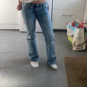 Blå jeans med bootcut - Säljer ett par snygga blå jeans med bootcut. Den första bilden är lånad, men jeansen är exakt likadana förrutom att dom ej är slitna längst ner💙De är lågmidjade och har en klassisk femficksdesign. Perfekta för en avslappnad vardagslook eller en utekväll. Passar bra med sneakers eller klackar!