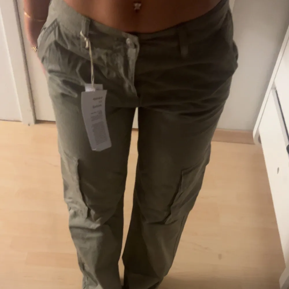 Assnygga gröna lågmidjade cargopants från gina som levlar upp din outfit lite extra. Dom är helt nya med prislapp och kostade orginalt 500kr och är i storlek 34 . Jeans & Byxor.