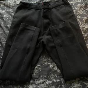 Svarta mjukisbyxor från acg - Säljer ett par svarta byxor i bra skick. De har praktiska dragkedjor på fickorna och en bekväm passform. Perfekta för vardagsbruk eller träning. Några små märken finns, men inget som stör funktionen.