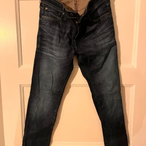 Mörkblå jeans från Jack & Jones - Säljer ett par snygga mörkblå jeans från Jack & Jones. De har inga defekter eller skavanker alls och är i mycket bra skick, säljs då de inte kommer till användning. Bara att kontakta om frågor eller fler bilder!