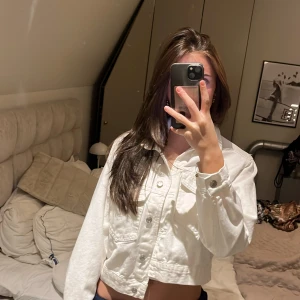 Vit croppad jeansjacka - Säljer en superfin vit croppad jeansjacka från Gina Tricot i mycket bra skick. 100% bomull. Den har långa ärmar och knappar framtill. Perfekt för vår och sommar, och funkar både till vardags och fest. Jackan är i storlek xs! Bara använd en gång.