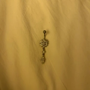 Glittrigt navelpiercingsmycke - Smycket är köpt på india piercing, ca 300-400kr. Smycket är i äkta silver och staven som sitter i huden är gjord av titan