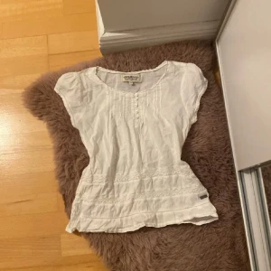 Vit blus från Hampton Republic - Säljer en söt vit blus från Hampton Republic i storlek 106. Blusen har korta ärmar och fina knappar framtill. Perfekt för vår och sommar med sitt lätta bomullsmaterial och stilrena design. Passar både till vardags och festliga tillfällen!