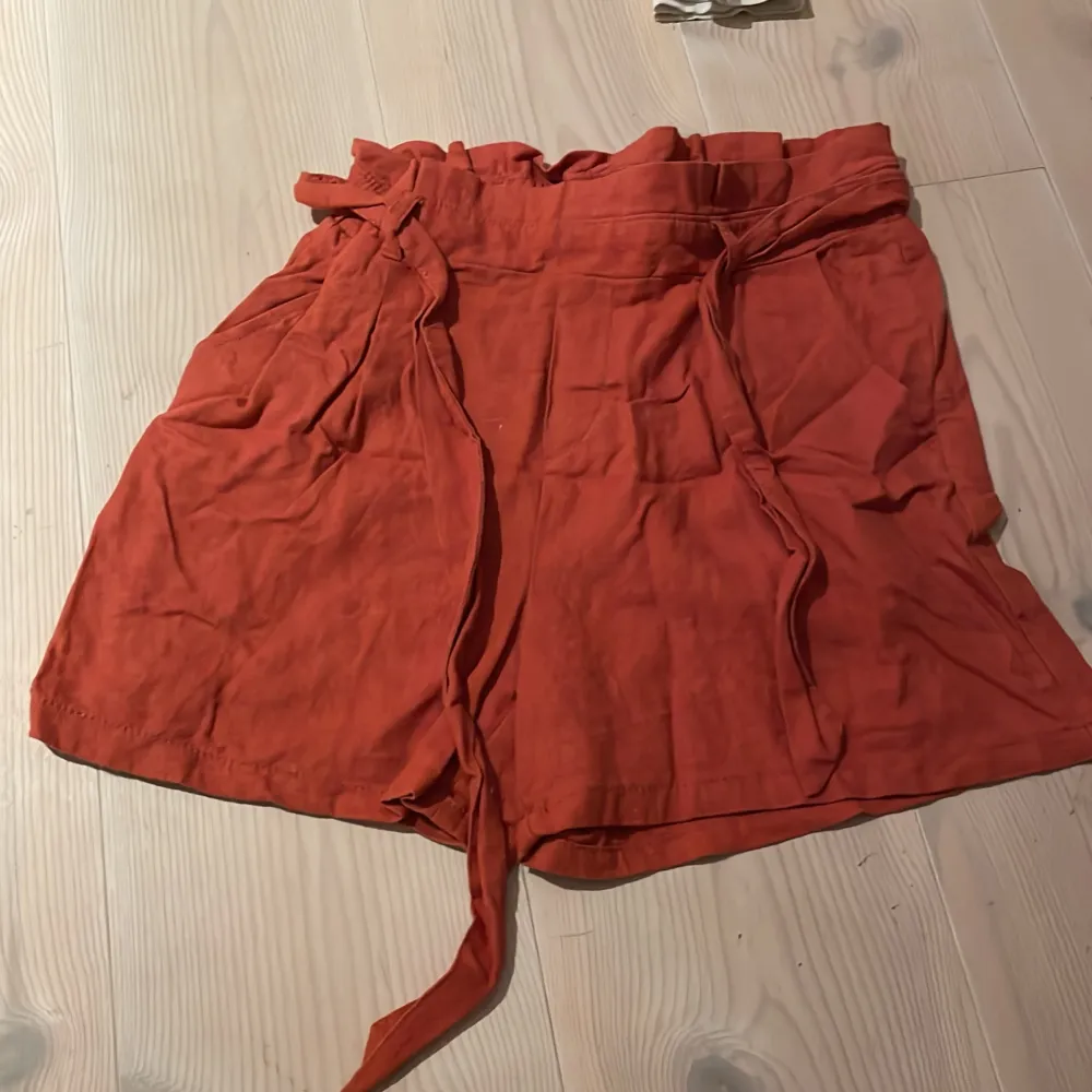 Säljer ett par snygga rostfärgade shorts från Lindex i storlek EUR 170. De är gjorda i ett mjukt och bekvämt material med knytband i midjan för en justerbar passform. Perfekta för sommarens varma dagar! 🌞. Shorts.