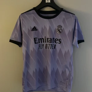 Lila Real Madrid fotbollströja - Säljer en snygg lila Real Madrid fotbollströja från Adidas i mycket bra skick. Tröjan är helt oanvänd.