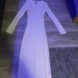 Vit långklänning - Säljer en elegant vit långklänning i ribbat material. Klänningen har en slim passform och långa ärmar, perfekt för en stilren look. Den är i mycket bra skick och passar utmärkt till både fest och vardag. Perfekt för vinterns alla tillfällen!