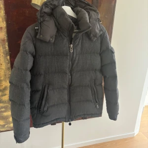 Moncler Montegenevre Size 2 - Säljer en snygg grå dun jacka från Moncler i fint skick. Jackan är i Storlek 2 som motsvarar S/M och givetvis äkta. Nypris på dessa idag ligger på cirka 19000kr.  Den finns i Stockholm eller postas spårbart och försäkrat om så önskas 