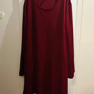 Vinröd klänning från Freequent - Säljer en stilren vinröd klänning från Freequent i storlek XL. Klänningen har en enkel design med långa ärmar och en rund halsringning. Perfekt för höst och vinter, både till vardags och festligare tillfällen. Materialet känns mjukt och bekvämt mot huden.