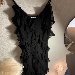 Svart volangklänning från NA-KD - Svart volangklänning från NA-KD i storlek 34. Klänningen har justerbara band och är i fint skick 