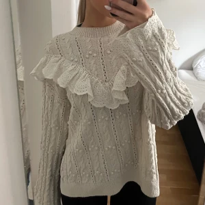 Stickad tröja Zara  - Superfin beige stickad tröja med volangdetaljer över axlarna. Perfekt för höst och vinter när du vill vara både varm och stilren. 
