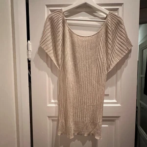 Glittrig topp - Säljer en superfin glittrig beige nästan ljusrosa nyans  topp med ribbad struktur. Materialet är mjukt stretchig och bekvämt, vilket gör den idealisk för både vardag och fest. Toppen är i mycket bra skick och redo för nya äventyr!