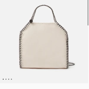 Beige väska från Stella McCartney - Jätte populär väska från stella mcartney, nypris 9200kr. Den är ganska sliten då jag andvönd den runt 1 år annars bra skick utom några fläckar. Storlek mini