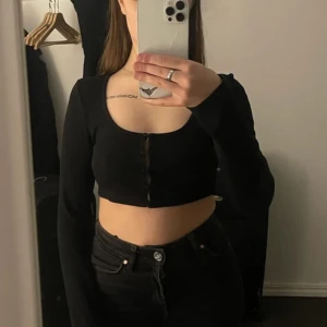 Svart tröja - Säljer denna korta tröja som passar perfekt till ett par högmidjade jeans!