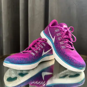 Nike - Run Natural Free & Flexible i cerise/lila/blå. Stl 36,5 mycket sparsamt använda.  