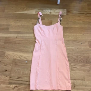 Rosa klänning med guld band  - En rosa klänning med guldiga kedjeband - oanvänd