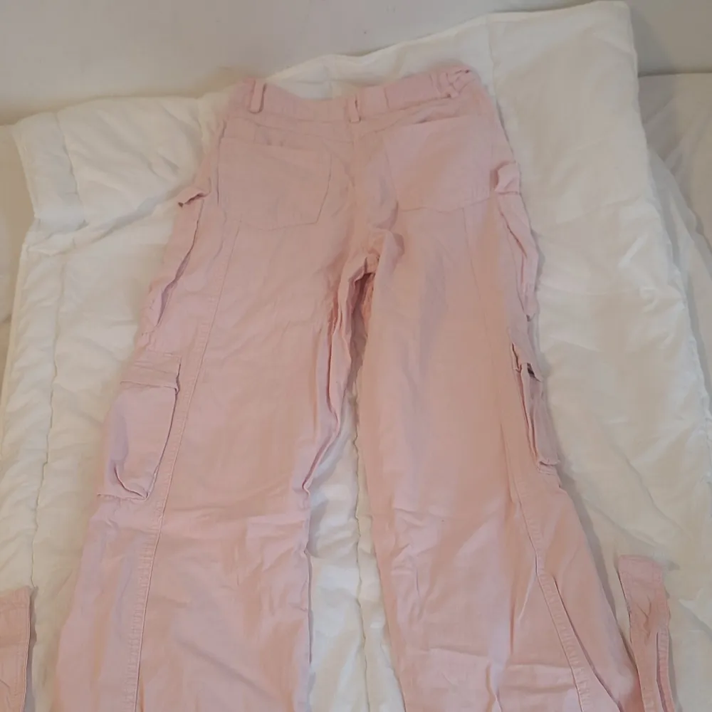 Säljer ett par ljusa rosa cargopants i storlek 32. De har flera praktiska fickor och kan sjusteras längst ned på byxorna. Använda en gång. Som nya, inga fläckar eller hål.. Jeans & Byxor.