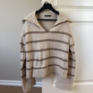 Stickad tröja  - Säljer min beige randiga stickade tröja från Gina Tricot. Super fin till hösten🍂. Den är som ny. Slits i slutet av ärmen som man ser på sista bilden. 