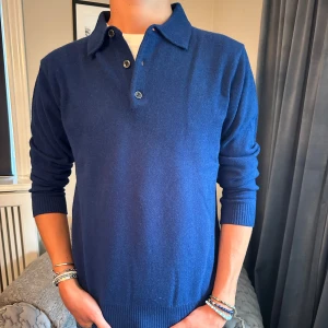 Mörkblå cashmeretröja - Pikétröja med knappar i cashmere, stilren och passar till allt. Helt i nyskick.