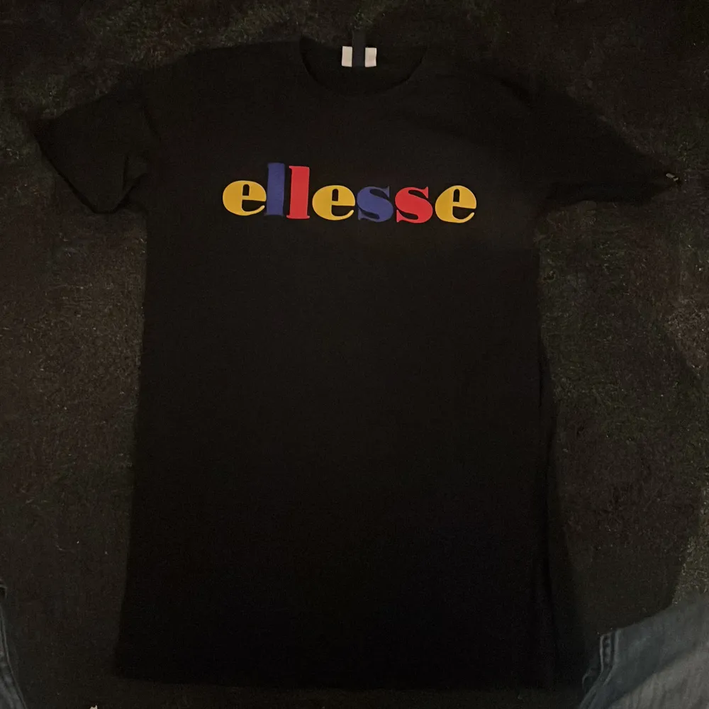 Svart t-shirt med färg glatt tryck av märket Ellesse. Mycket gott skick, endast använd ett par gånger.  Levereras tvättad i väl packeterad låda till både Instabox eller Postnord.. T-shirts.