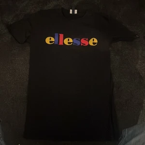 Svart Ellesse t-shirt - Svart t-shirt med färg glatt tryck av märket Ellesse. Mycket gott skick, endast använd ett par gånger.  Levereras tvättad i väl packeterad låda till både Instabox eller Postnord.