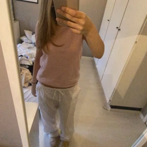 Rosa kortärmad topp - Säljer en söt rosa kortärmad topp i mjukt material. Perfekt för en avslappnad vardagslook eller att styla upp för en somrig dag. Toppen har en enkel och stilren design.