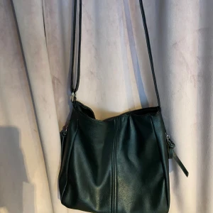 Svart handväska💗💗 - Superfin svart axelväska i skinn och den har en lång justerbar axelrem. Perfekt för vardagsbruk eller när du är på språng. Väskan är i fint skick och knappt använd😍🫶🏼nypris 300kr. Vid mått elr liknande hör gärna av dig💗