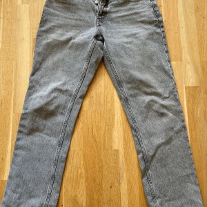 Grå jeans från Zara - Säljer ett par grå jeans från Zara i storlek 38. De är i bra skick och har en klassisk femficksdesign med knappar. Perfekta för vardagsbruk och kan matchas med nästan vad som helst. Passa på att fynda dessa snygga jeans!