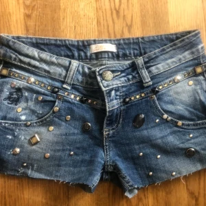 Coola jeansshorts  - Coola jeansshorts med spets på fickorna och ”paljetter” på framsidan. Lågmidjade från märket justor.