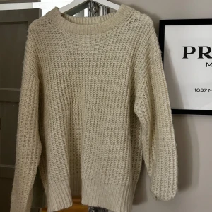 Vit stickad tröja - Mysig vit stickad tröja perfekt för kyliga dagar. Den har en avslappnad passform med långa ärmar och en rund halsringning. Tröjan är i ett mjukt material som håller dig varm och bekväm hela dagen. Perfekt för både höst och vinter och sommar