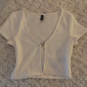 Vit cover up t-shirt  - Vit cover up t-shirt med en metall fjäril i mitten!  Använd någon gång, men har inga skador/ slitage!