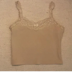 Vitt spets linne - Jättefint krämvit spets linne med rosett som använts några gånger, men den har inga skador/ slitage. 