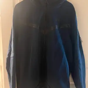 Nike tech hoodie, marin blå. Inte använd mycket alls, i modell för herr men jag som tjej har använt den.