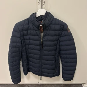 Parajumper jacka dam - Här har vi en snygg och relativt ny jacka i jättebra skick. Den är i marin blå med beige insida. Det är äkta parajumper i storleken M. Passar perfekt till höst och vår. 