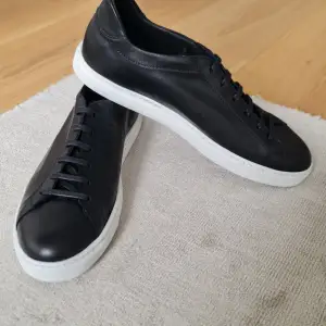 Säljer ett par sneakers i äkta läder, tillverkade i Portugal. Mycket hög kvalité på material. Storlek EU43. 