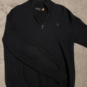 Marinblå tröja med dragkedja från Polo Ralph Lauren - Snygg marinblå tröja från Polo Ralph Lauren med dragkedja vid halsen. Skick 9/10 då jag inte har använt den så mycket, inga detekter eller liknande. Pris går att diskuteras.