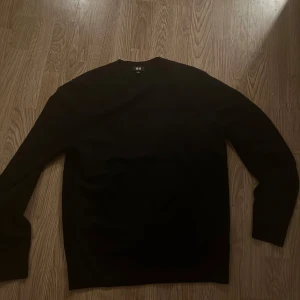 Svart tröja från Uniqlo/ Kashmere - Säljer en stilren svart tröja från Uniqlo i storlek S. 100% Kashmere. Tröjan är långärmad och tillverkad i mjukt material, perfekt för kyligare dagar. Enkel design som passar till det mesta.