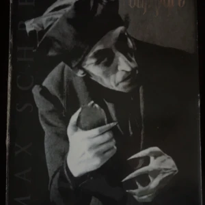 Nosferatu - Eine Symphonie des Grauens - Samlarobjekt från filmen 'Nosferatu' med en figur av karaktären i en grå kappa och svarta byxor. Inkluderar extra tillbehör och en bakgrund med stenmotiv. Perfekt för filmälskare och samlare av klassiska skräckfilmer.