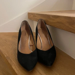 Svarta pumps från Caprice - Eleganta svarta pumps från Caprice med spetsig tå och klack. Perfekta för en stilren look.