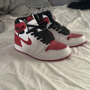 Nike Air Jordans Heritage - Snygga Nike Air Jordans i klassisk röd och vit färgkombination. Skorna har svart snörning och en hög design som ger extra stöd. Perfekta för dig som vill ha en stilren och sportig look. Köpt på Stockx, har kvitto 