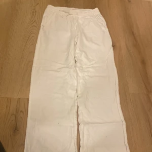 Vita byxor från 157 - Säljer ett par vita byxor från 157. De har en elastisk midja och en bakficka. Perfekta för en avslappnad stil. Priset kan diskuteras! 