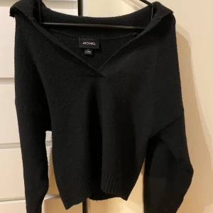 Svart stickad tröja från Monki - Säljer en svart stickad tröja från Monki med v-ringad design. Tröjan har långa ärmar och är tillverkad i ett mjukt material som ger en bekväm passform. Perfekt för kyligare dagar.