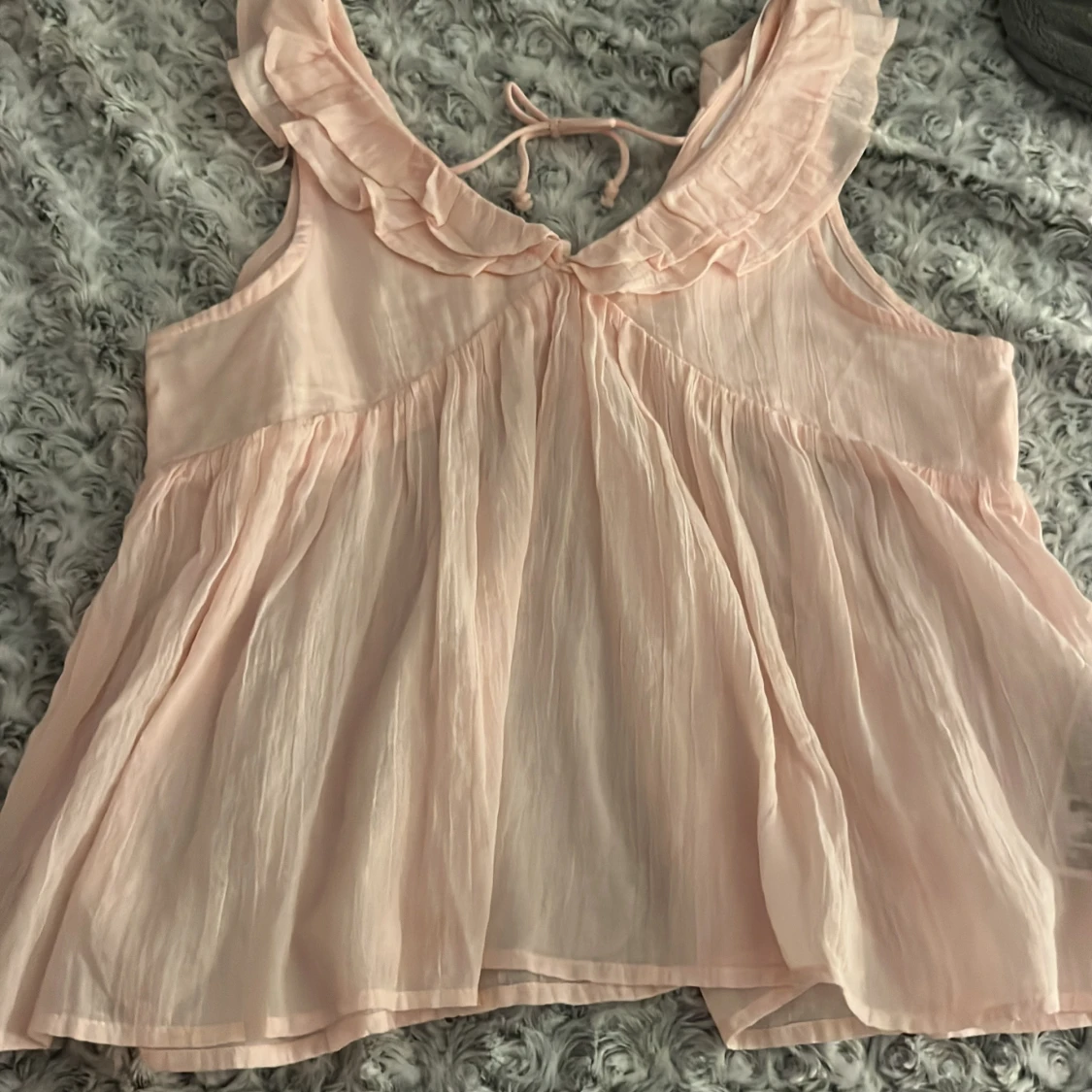 Ljusrosa blus med volang