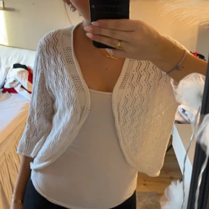 Vit spetskofta - Säljer en söt vit spetskofta med trekvartsärm. Perfekt för att lägga till en romantisk touch till din outfit. Koftan har ett fint mönster och knäpps framtill. Passar bra till både vardag och speciella tillfällen. Står att det är storlek XXL men jag har s/m och den passar mig 