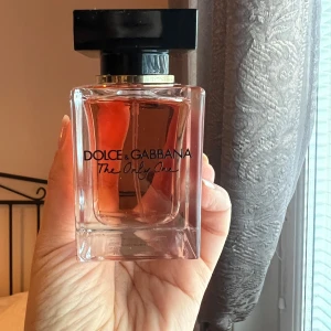 Dolce & Gabbana The Only One Eau de Parfum - Säljer en elegant flaska av Dolce & Gabbana The Only One Eau de Parfum. Flaskan rymmer 50 ml och har en stilren design med en svart fyrkantig kork och gyllene detaljer. Doften är känd för sin unika och förföriska karaktär.