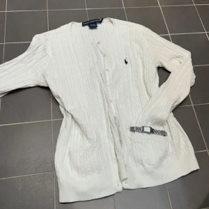 Vit kofta från Ralph Lauren - Snygg vit kofta från Ralph Lauren! Bra passform och skön! Tjejen på bilden har vanligvis storlek S men koftan är liten i storlek och är storlek L, men den sitter bra endå!