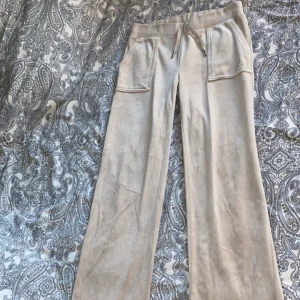 Jucy Couture byxa (Beige) - Köpt från Jucy’s egna hemsida för inte så länge sen. Använd fåtal gånger, mycket bra skick! Obs‼️(se sista bild) enderna på byxan har slitage då byxorna va långa på mig. Annars inga defekter!