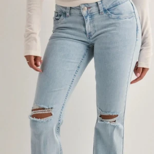 Ljusblå jeans med slitningar - Snygga ljusblå Nelly jeans med slitningar på knäna och broderade bakfickor. Lågmidjade och väldigt populära. Skulle säga hyfsat små i storleken 💘💘Byxorna är superbra skick då de ändats är använda 5 gånger. 