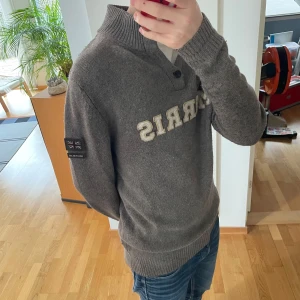 Morris Stickad Cardigan - Säljer en sjukt unik Cardigan/Tröja från Morris. Tröjan är grå/brun och är gjord i ett skönt material troligtvis någon sorts ull och den är i bra skick. Den har även en jättebra passform, sitter i strl M och är sjukt populär! Hör gärna av er vid frågor eller funderingar!!