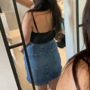 Jeanskjol i blått - Snygg jeanskjol i blått med klassisk design. Kjolen har en knapp och dragkedja framtill samt två fickor bak. Perfekt för en avslappnad stil.