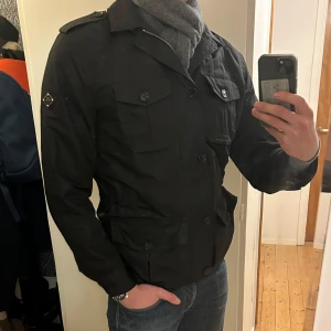 Svart jacka från J.Lindeberg - Svart jacka i large från J.Lindeberg. Jackans ärmar kan vikas upp och midjan kan justeras. Tveka inte att höra av dig vid fundering eller behov av fler bilder! Pris kan diskuteras.